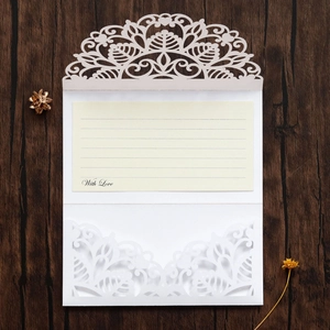Detail of laser cut wedding invitation with hollow floral design and With Love text insert
