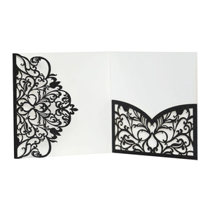Macro detail of laser-cut baroque pattern on black glitter paper wedding invitation