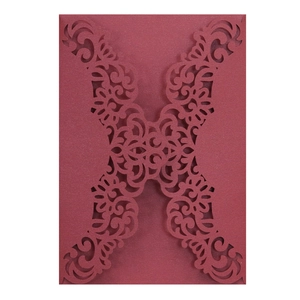 Detailed laser-cut pattern on burgundy pearl paper for elegant wedding invitations