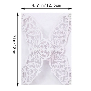 Detail of laser-cut white wedding invitation with intricate floral lace pattern