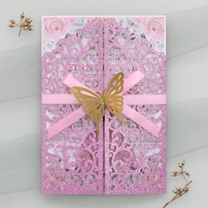 Détail de l'invitation de mariage rose découpée au laser avec ruban et papillon doré