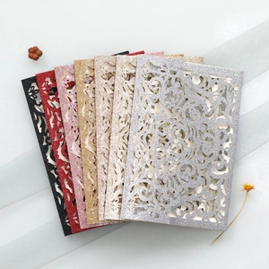 Macro detail of laser-cut glitter wedding invitation covers with intricate floral patterns