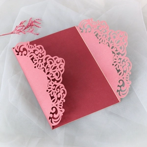 Detail of laser-cut floral pattern on elegant red and pink wedding invitation envelope