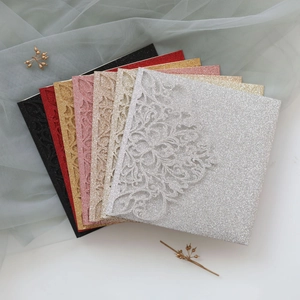 Detailed laser-cut floral pattern on glitter paper wedding invitation envelopes