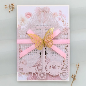 Detail of pink laser cut wedding invitation with glitter finish and gold 3D butterfly