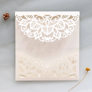 Detailed laser-cut mandala and floral patterns on an ivory pearl wedding invitation