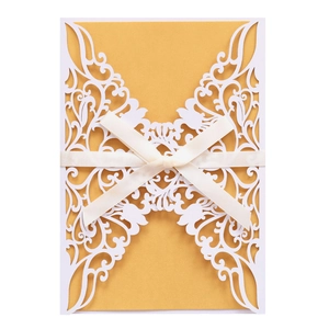 Laser-cut floral wedding invitation set with white ribbon bow and gold insert card