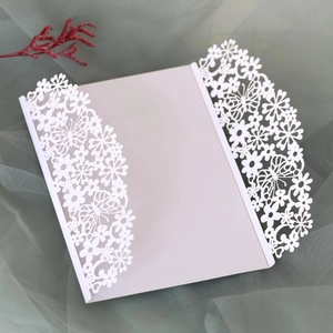 Detailed laser-cut butterfly and floral patterns on elegant white wedding invitation cover