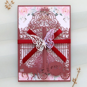 Detailed view of laser-cut wedding invitation with red ribbon and 3D butterfly ornament