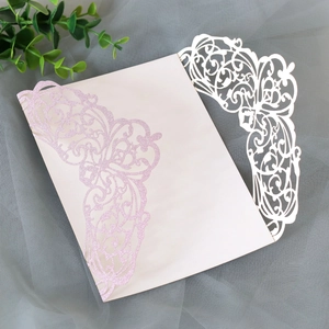 Detail showing laser-cut floral pattern and pink glitter coating on wedding invitation card