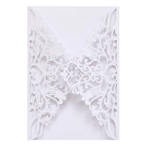 Macro detail of laser-cut white wedding invitation shell with elegant floral pattern