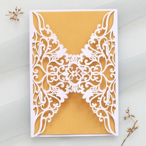 Detail of laser-cut wedding invitation cover with gold insert on elegant blue tulle