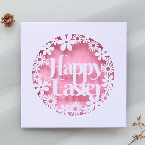 Detail of laser-cut Happy Easter greeting card with floral patterns on a pink background