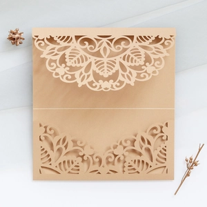 Close-up of laser-cut mandala patterns on elegant beige wedding invitation card