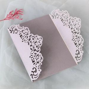 Macro shot of laser-cut lace floral pattern on pearl paper wedding invitation cover