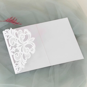 Detailed laser-cut baroque floral lace pattern on elegant white wedding invitation card