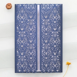 Détail d'invitation de mariage bleue découpée au laser avec motifs floraux ajourés