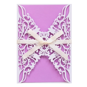 Detail of laser-cut butterfly invitation with purple insert and cream ribbon bow