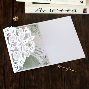 Detailed close-up of laser-cut lace invitation with floral succulent printed insert