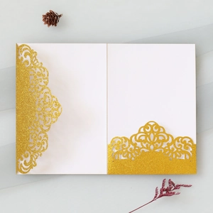 Detailed laser-cut gold glitter wedding invitation with elegant scrollwork patterns