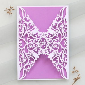 Detail showing elegant laser cut floral patterns on a violet wedding invitation card