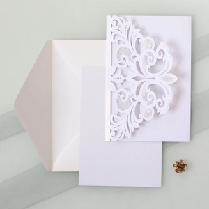 Detailed laser cut white wedding invitation set with baroque lace patterns and white envelope