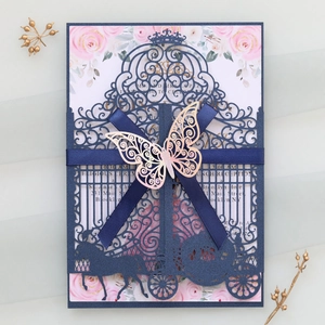 Intricate laser-cut pumpkin carriage wedding invitation with navy ribbon and butterfly