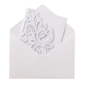 Close-up of laser-cut floral pattern on wedding invitation with white envelope