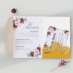 Macro shot of laser-cut floral wedding invitation with champagne gold glitter pocket detail