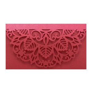 Close-up of laser-cut floral patterns on dark red pearlescent paper invitation cover