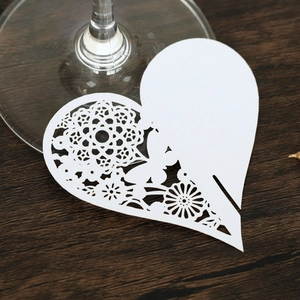 Detail of laser-cut white heart place card with lace pattern on a glass base