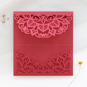 Detailed laser-cut burgundy invitation card with intricate floral patterns and elegant matte finish