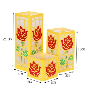 Set da tre lanterne di carta gialle con motivi a rose rosse tagliati al laser