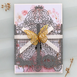 Detail of laser-cut glitter invitation with elegant gold butterfly and white ribbon bow