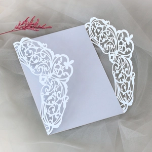 Intricate laser-cut white floral wedding invitation with soft lilac insert card
