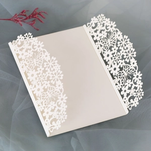 Detail of laser-cut butterfly floral invitation card on elegant mesh fabric background