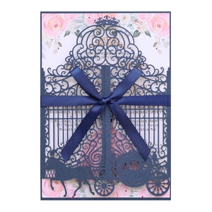 Detail of navy blue laser-cut wedding invitation with silk bow and floral insert