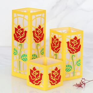 Tre paralumi in carta gialla tagliata al laser con motivi di rose rosse in varie misure