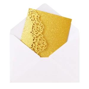Detail of laser-cut glitter gold wedding invitation card with elegant floral pattern