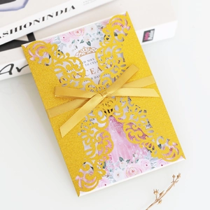 Vue macro de l'invitation de mariage dorée scintillante avec ruban en satin