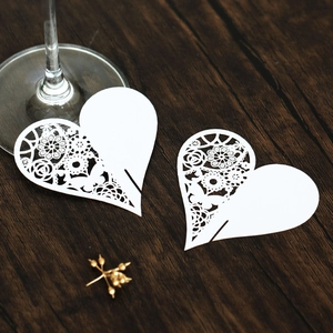 Macro view of white laser-cut heart cards with intricate floral butterfly patterns