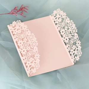 Detailed laser-cut hollow butterfly and floral design on light pink wedding invitation
