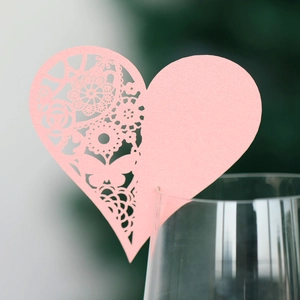 Pink heart-shaped laser-cut wine glass place card with delicate butterfly lace patterns
