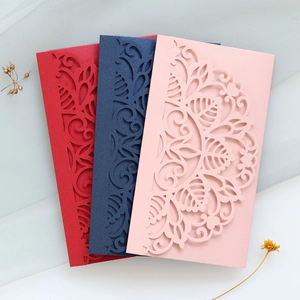 Detail of laser-cut wedding invitations in red, blue, and pink with floral patterns