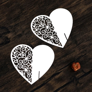 Detail of laser-cut heart place cards with scrollwork for wine glass decor