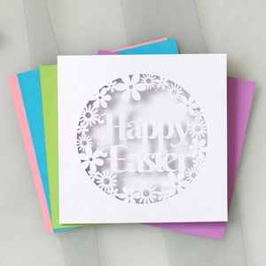 Macro view of white laser-cut daisy Easter card with colorful inserts and Happy Easter text