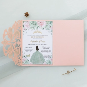 Macro detail of laser-cut pink lace wedding invitation with floral inner card