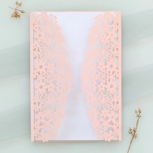 Detail of laser-cut butterfly invitation with pearl paper and floral lace pattern
