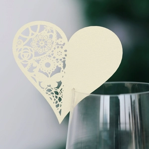 Macro detail of heart-shaped laser cut card on glass with delicate hollow floral patterns