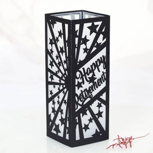 Detail of laser-cut black paper lantern with Happy Retirement text and stars